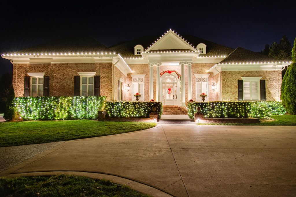 Christmas light installation across the roof edge and entry of a Nashville home